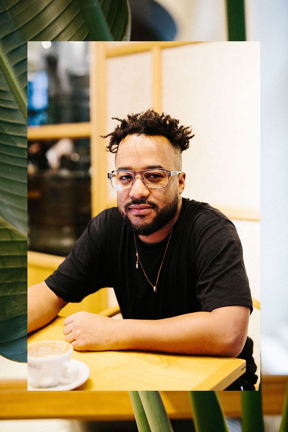 Nico Adomako in Ace & Tate glasses at a cafe table