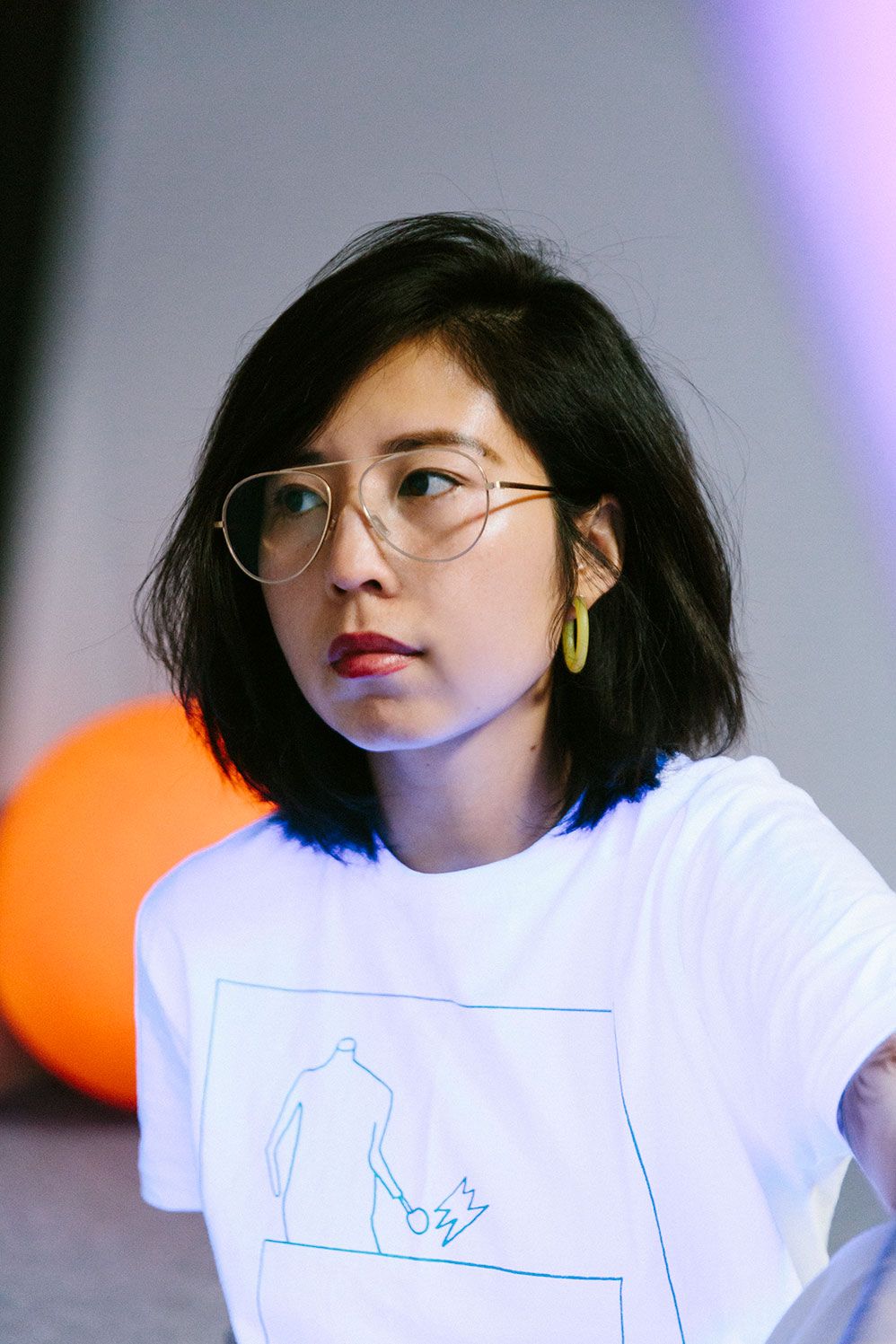 Ruohan Wang in round Ace & Tate glasses and a white T-shirt