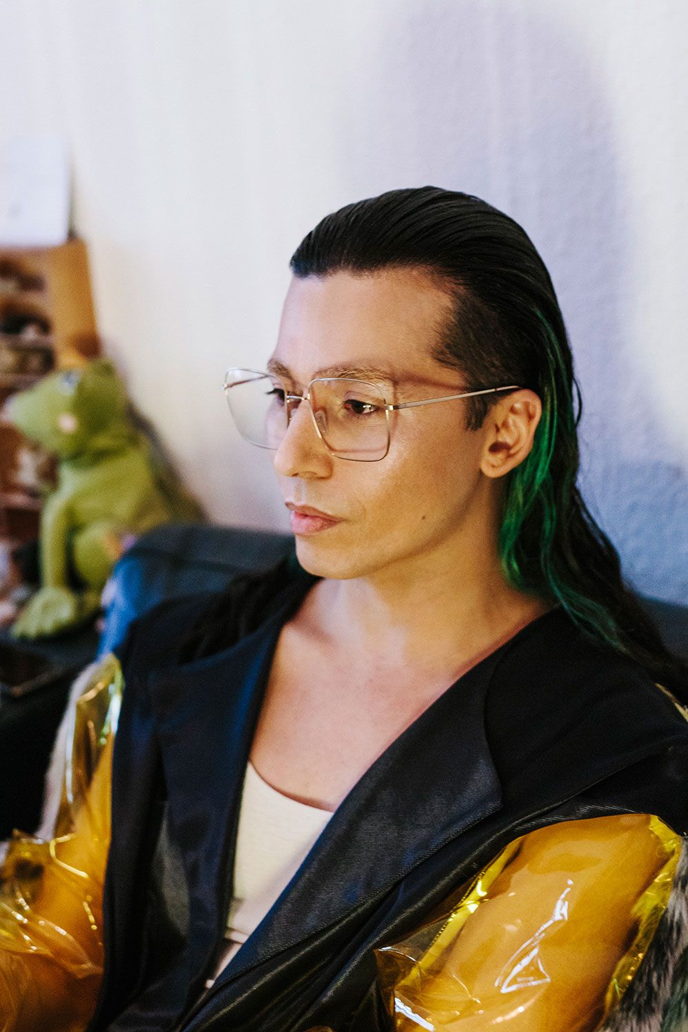 Mikey Woodbridge at home in clear Ace & Tate frames and a yellow jacket