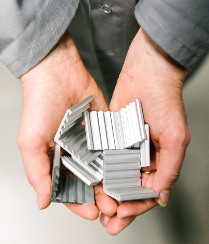 Hands holding aluminium frame profiles for aleo solar panels