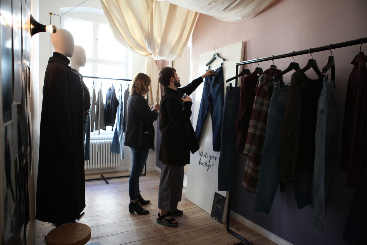 Two visitors looking through a rail of CLOSED coats and jackets during German Press Days