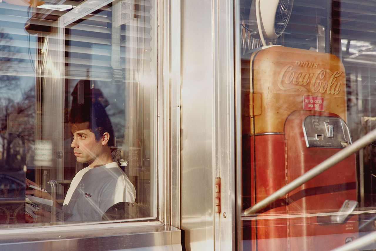 Graphic designer seen through the window of a New York diner