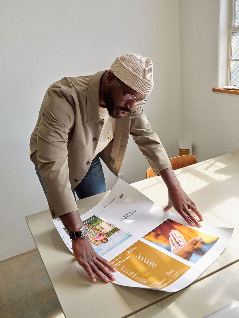 Creative director laying out magazine pages on a table at home