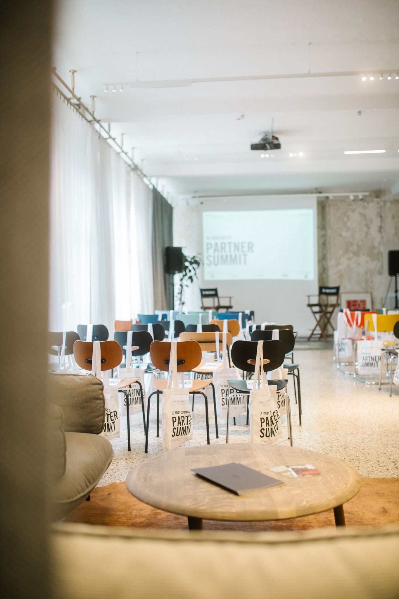 Rows of chairs facing a screen for the La Marzocco partner summit in the Friends Space