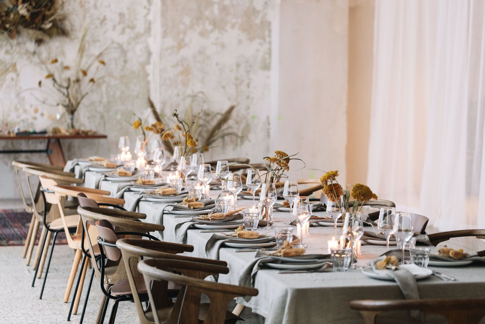 Long table set with linen, candles and dried flowers for a Manufactum dinner