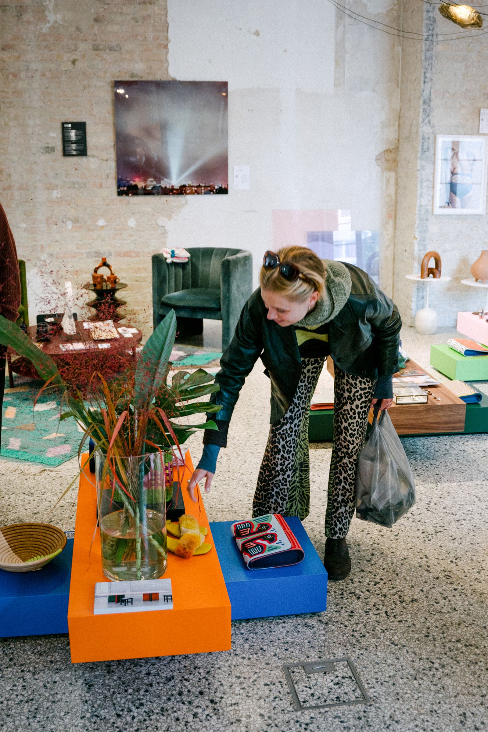 Visitor browsing a design pop-up store on colourful plinths in the Friends Space
