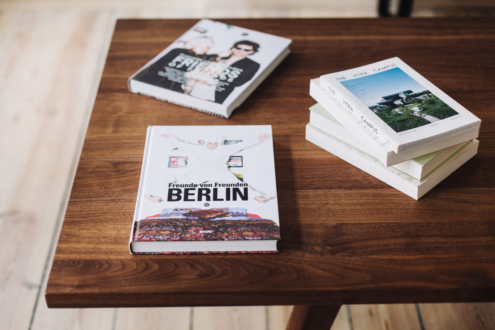 Stack of Freunde von Freunden books with the Berlin edition on top, on a walnut table