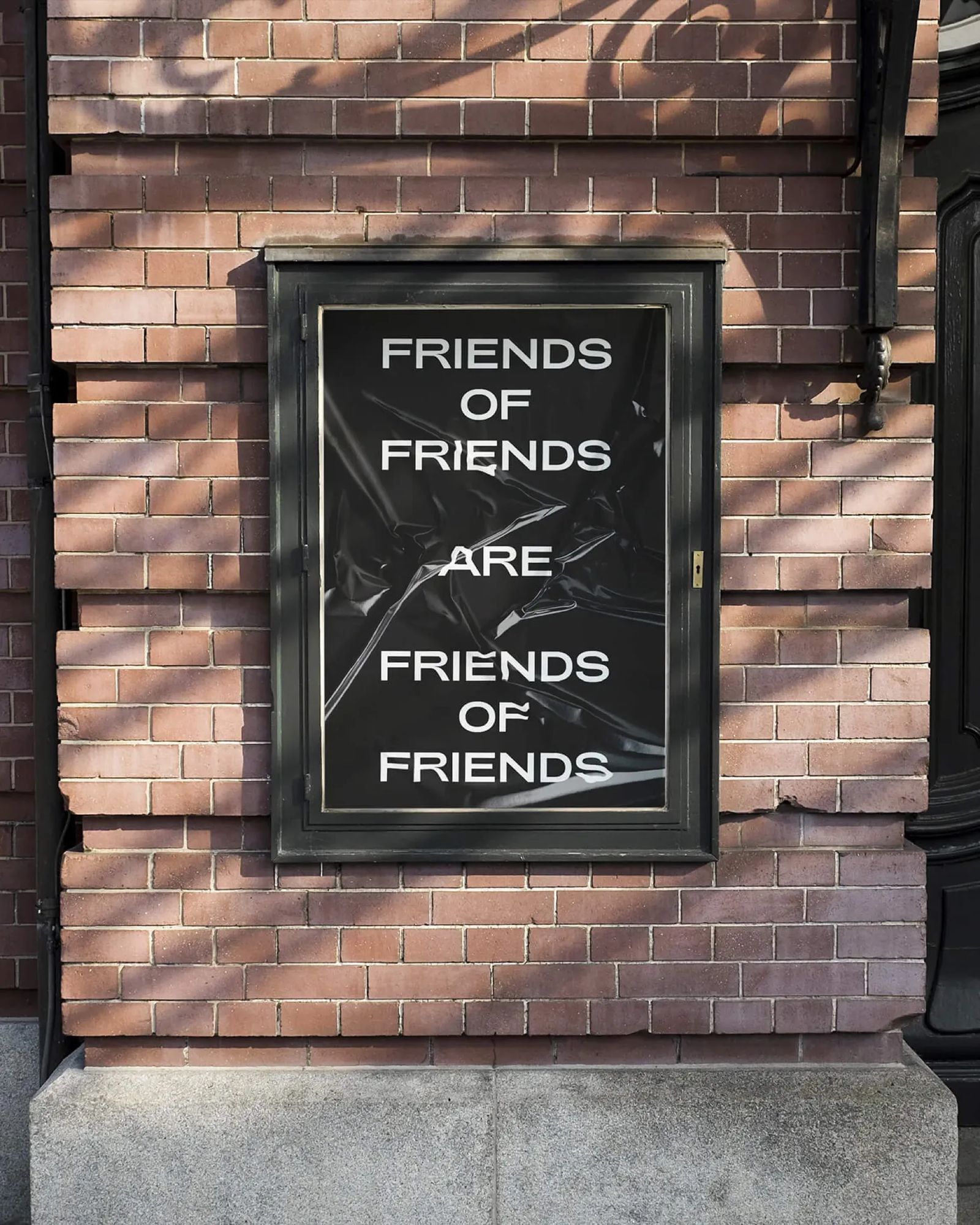 Friends of Friends typographic poster on a brick wall