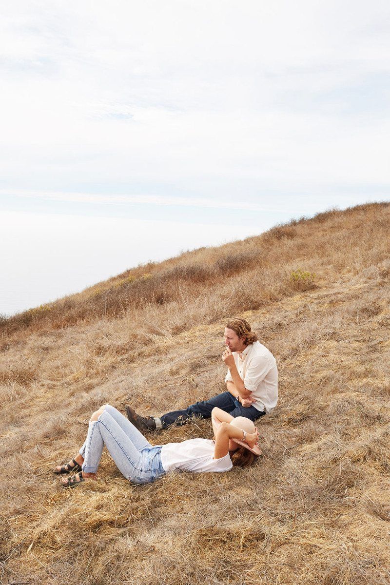 Freunde von Freunden portrait of a couple resting on a dry grassy hillside