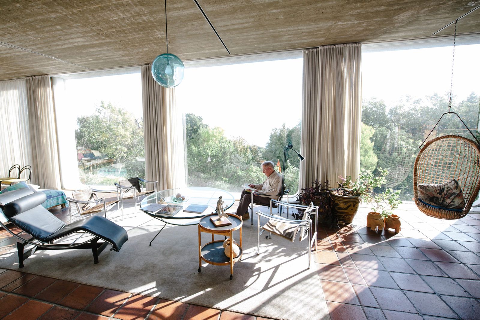 Sunlit modernist living room with floor-to-ceiling windows onto a garden, from a Freunde von Freunden home story