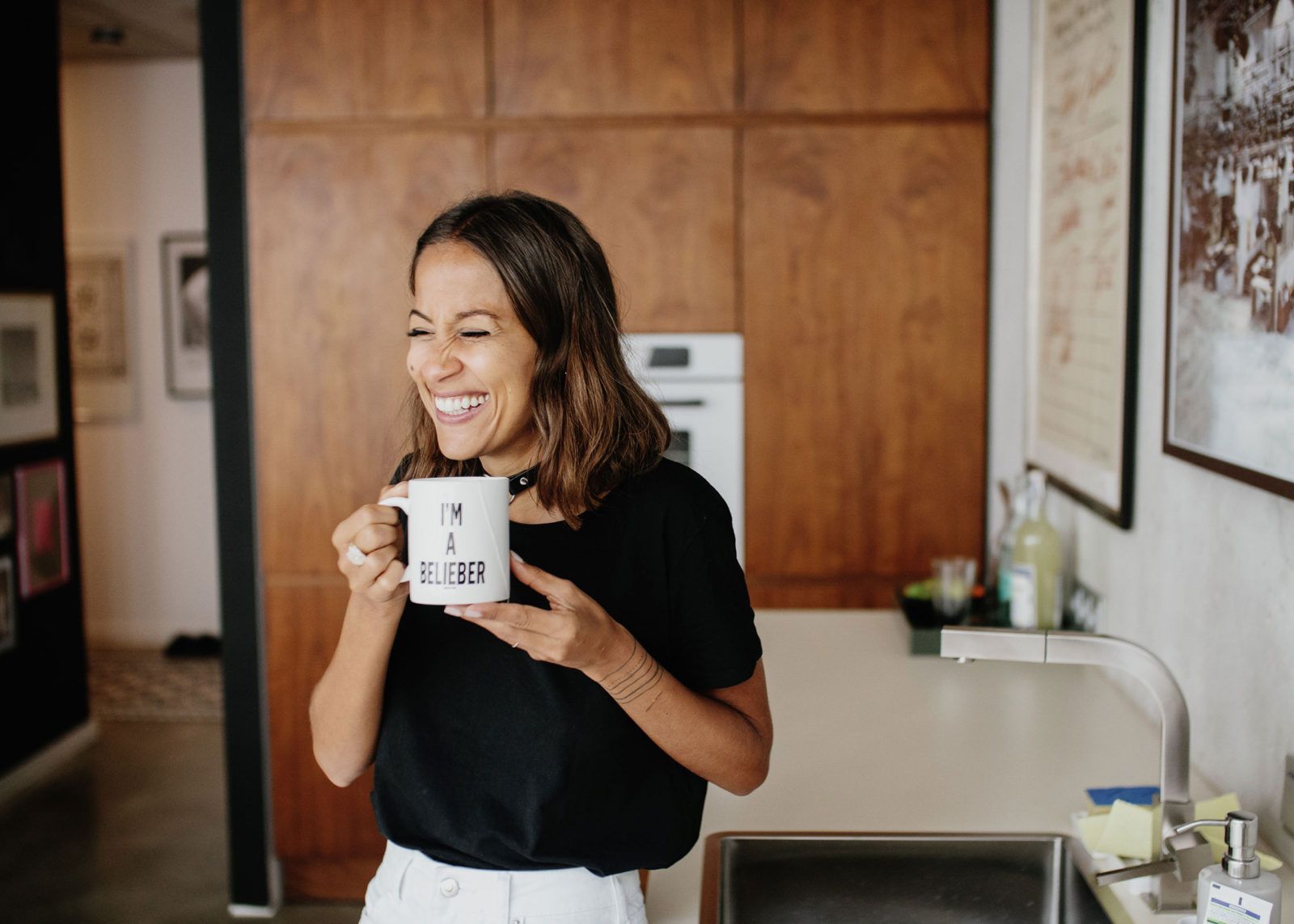 Laughing woman holding a mug in her kitchen, Freunde von Freunden portrait
