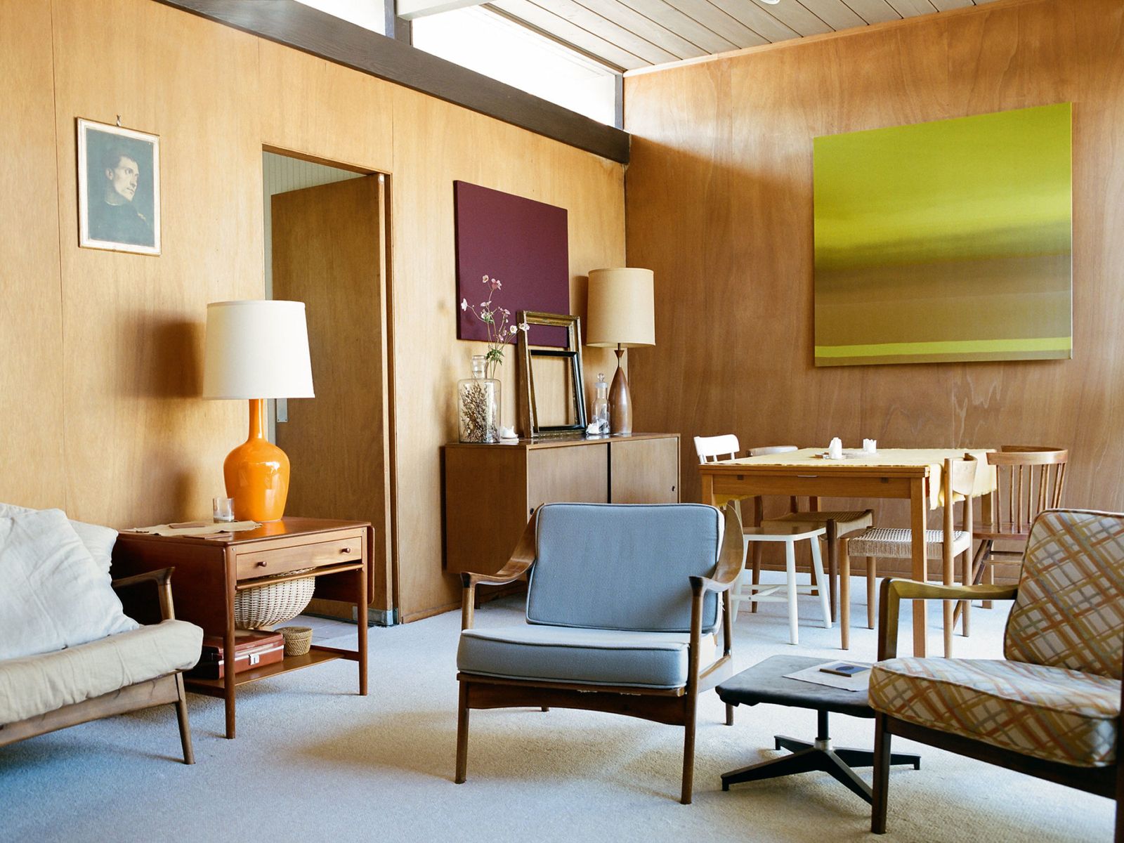 Wood-panelled mid-century living room with an orange lamp, photographed for a Freunde von Freunden home story