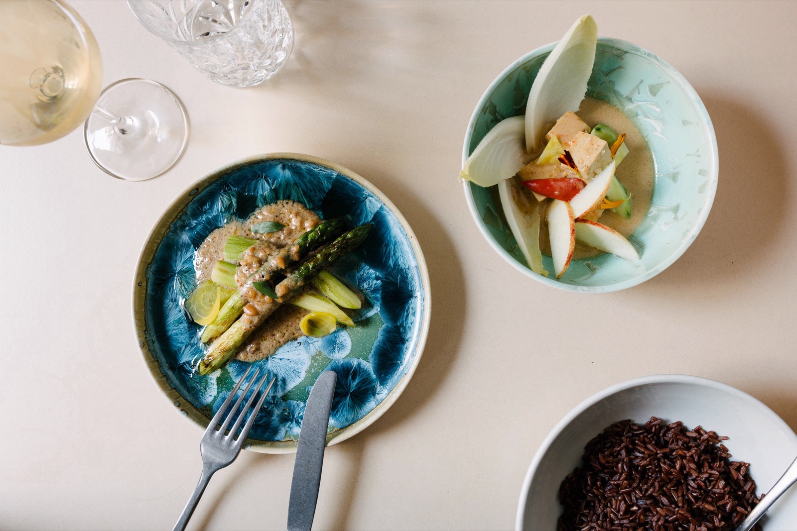 Overhead view of Thai dishes on blue and green plates at Kin Dee, Berlin