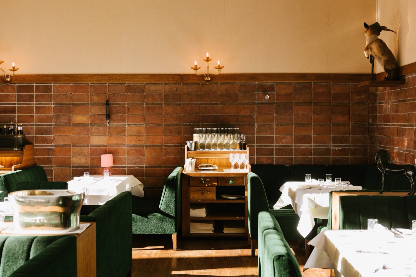 Pauly Saal dining room with green leather booths and brick walls