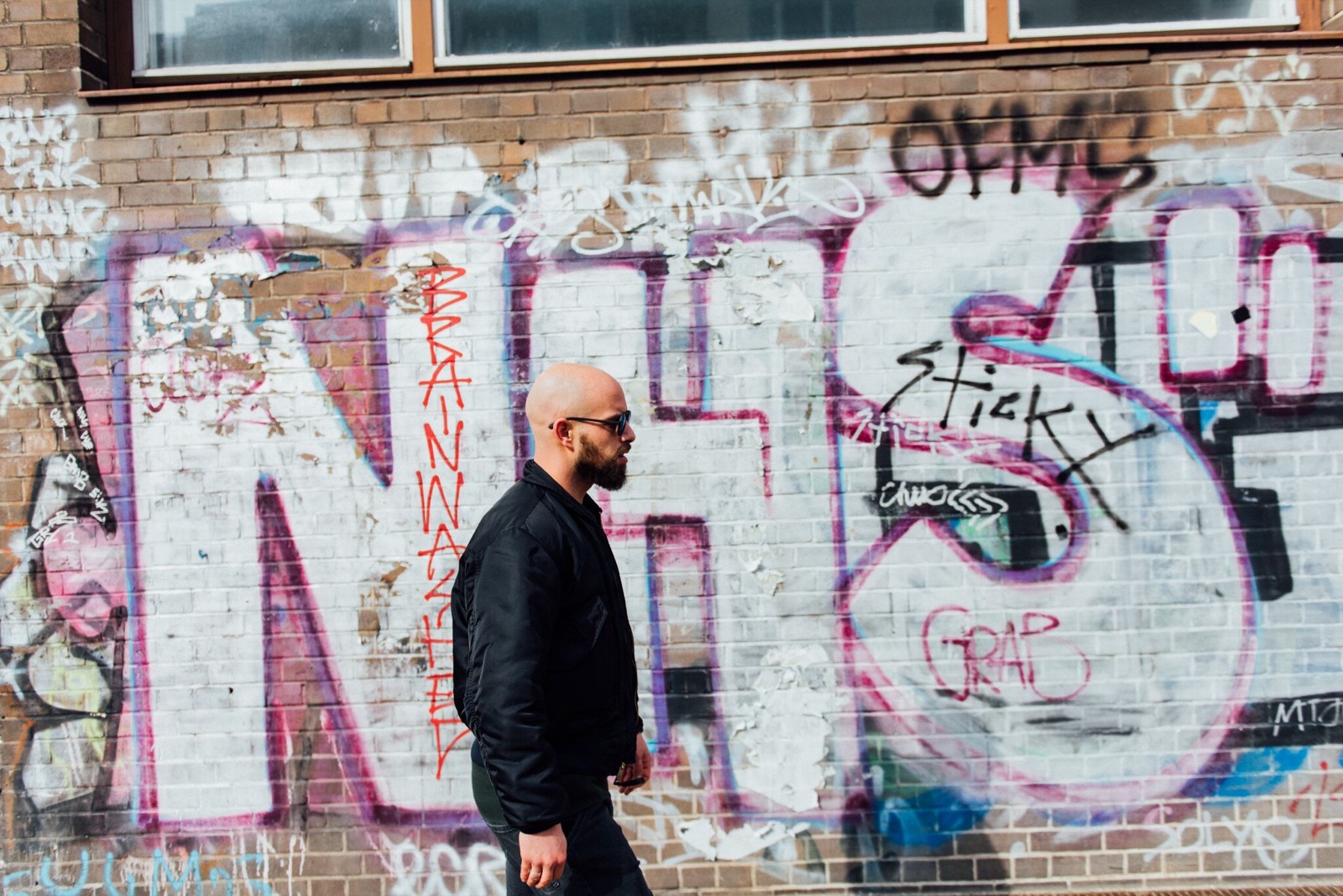 Berliner walking past a graffiti wall, You, Me & Berlin story for Hotel Berlin, Berlin