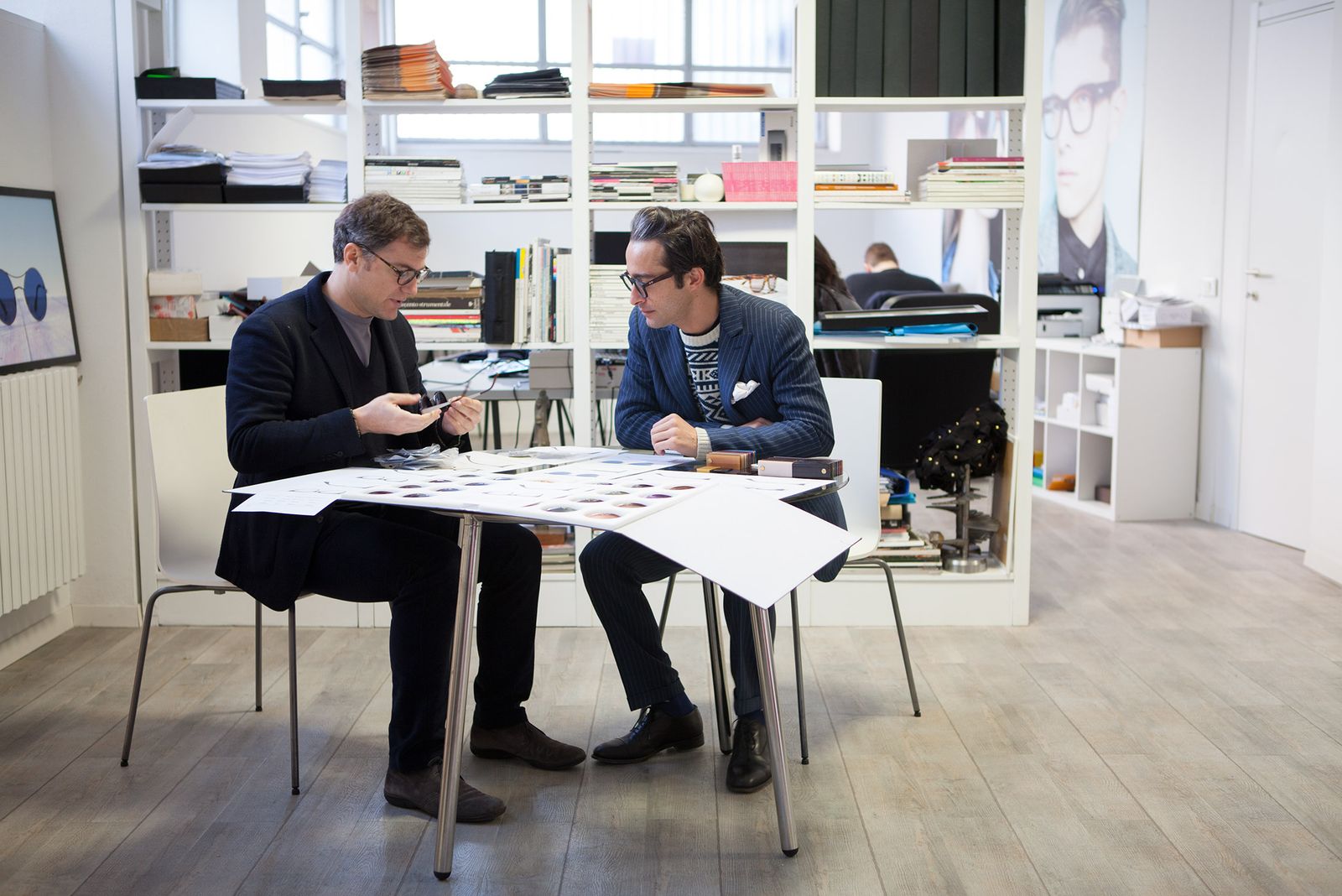 The TYG Spectacles team reviewing designs at a white table in Milan