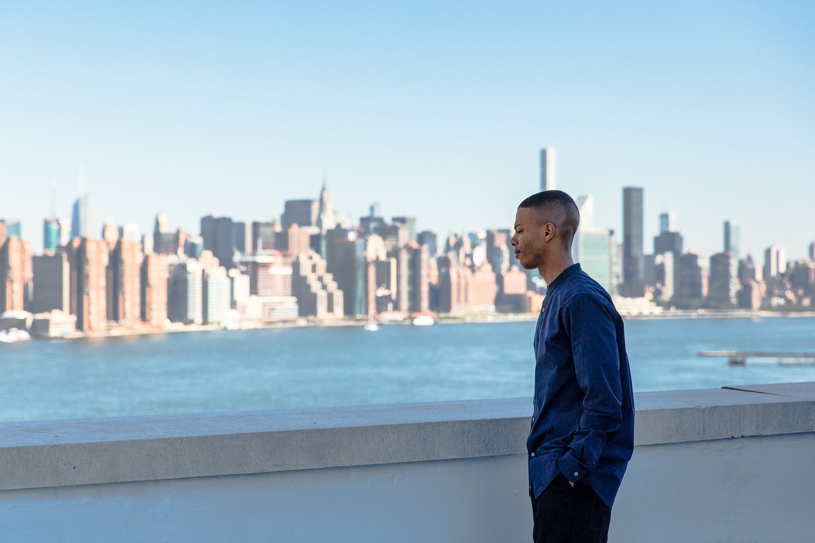 A No Wyld band member on a rooftop above the East River with the Manhattan skyline behind