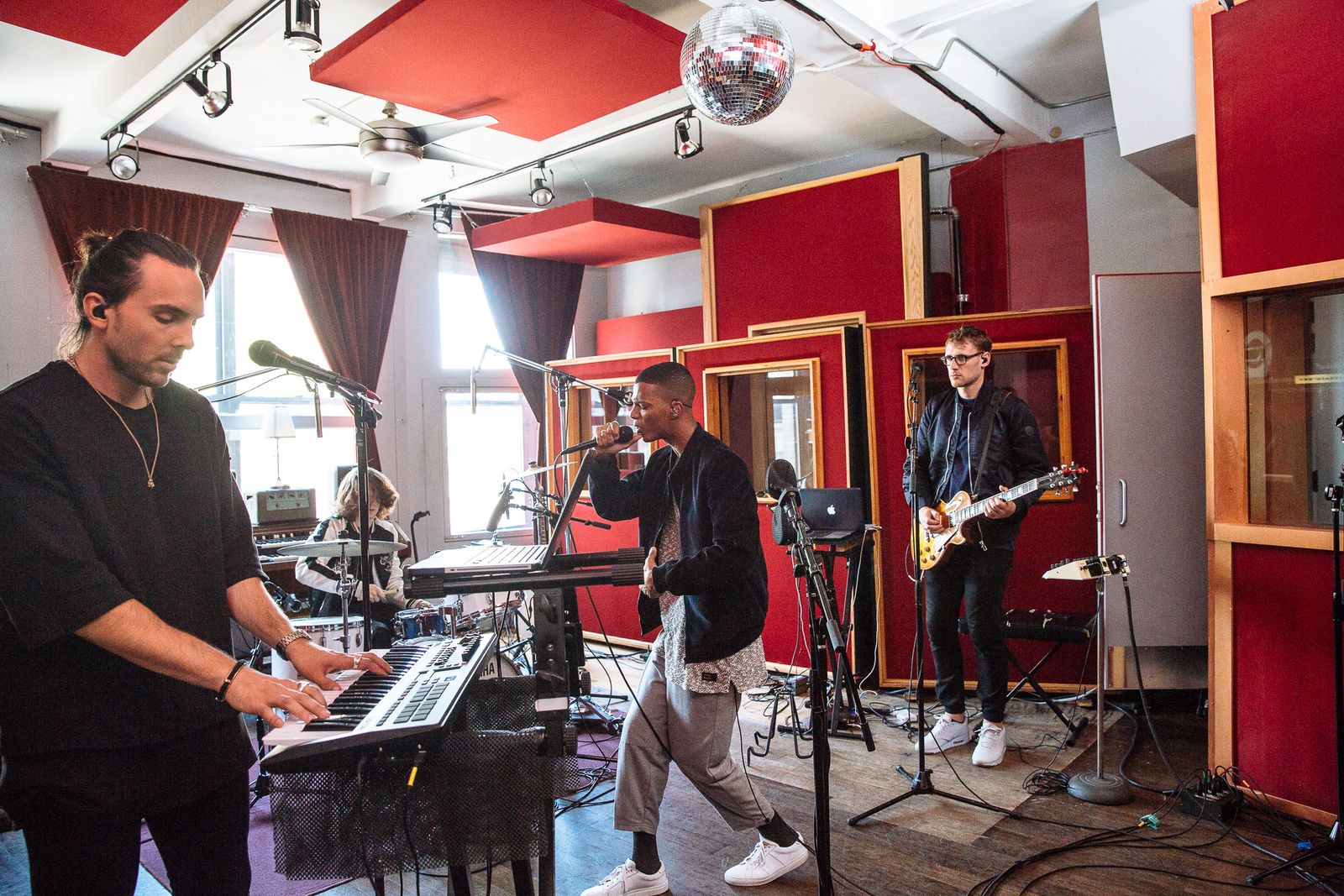 No Wyld playing keys, vocals and guitar in a red-panelled recording studio in New York