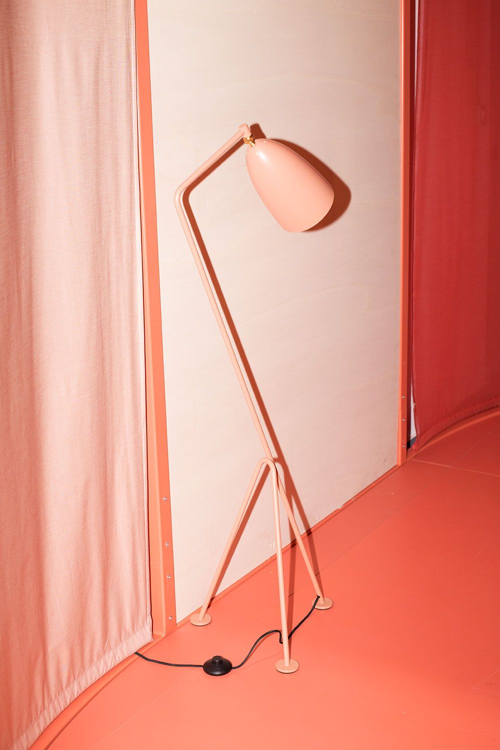 Coral-coloured living unit with a tripod floor lamp, Built by All, Milan