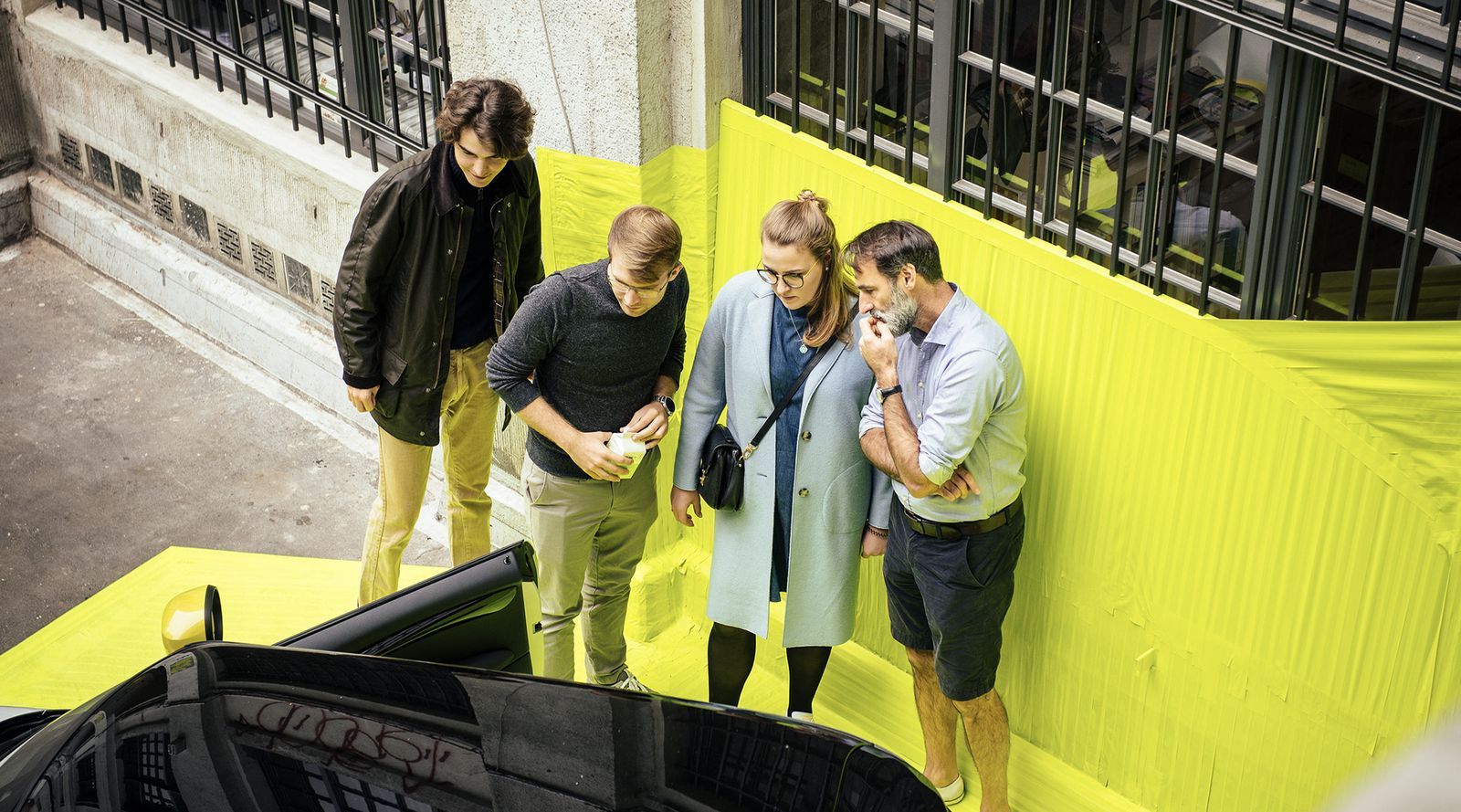 Guests looking at the MINI Electric inside the neon yellow installation in Berlin