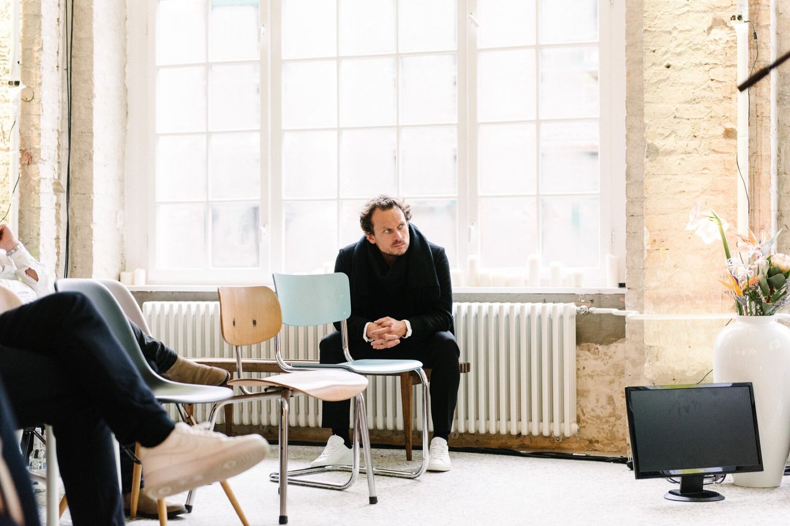 Speaker seated on stage in a bright loft at FvF Friends Space