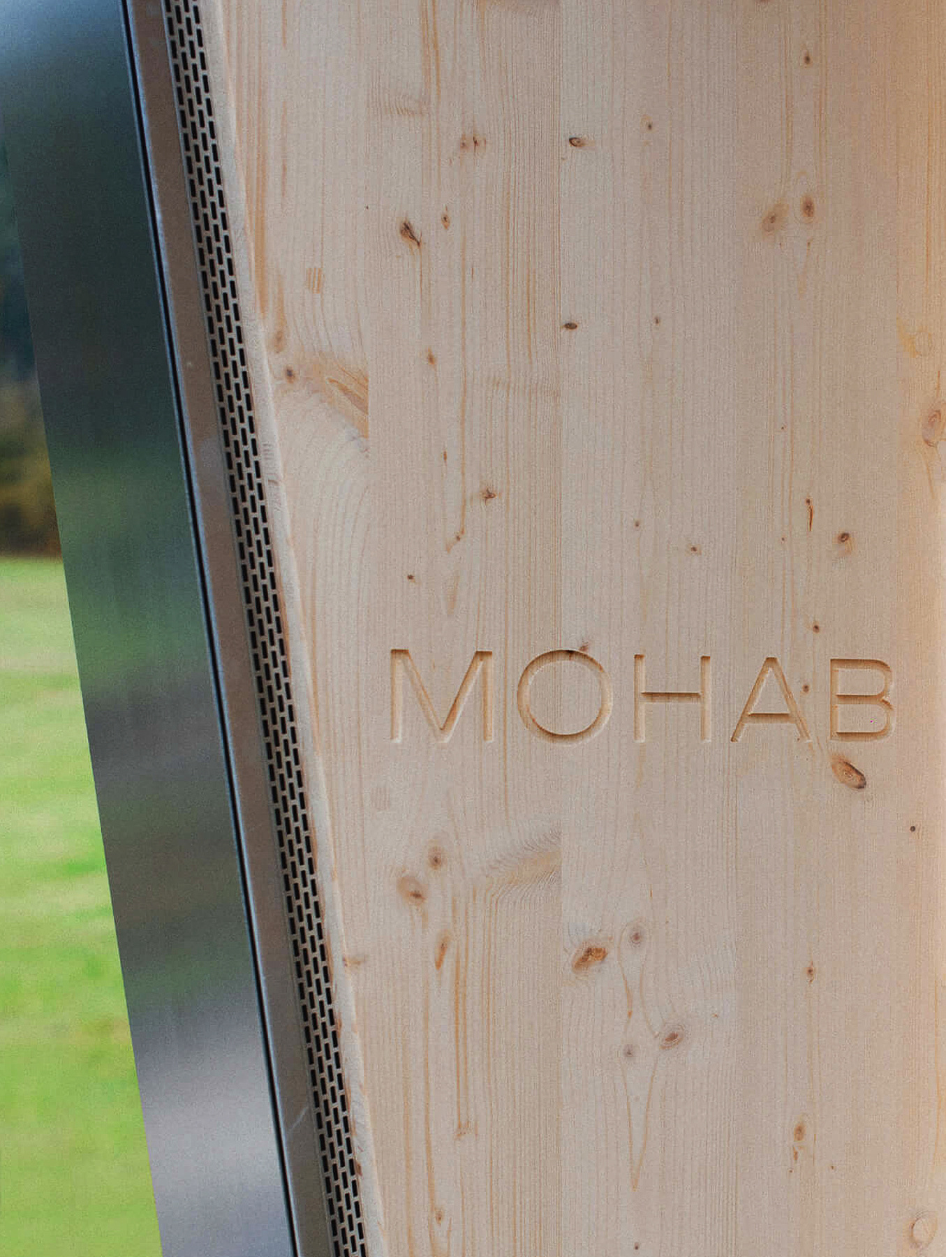 MOHAB logo engraved into a timber wall next to a window