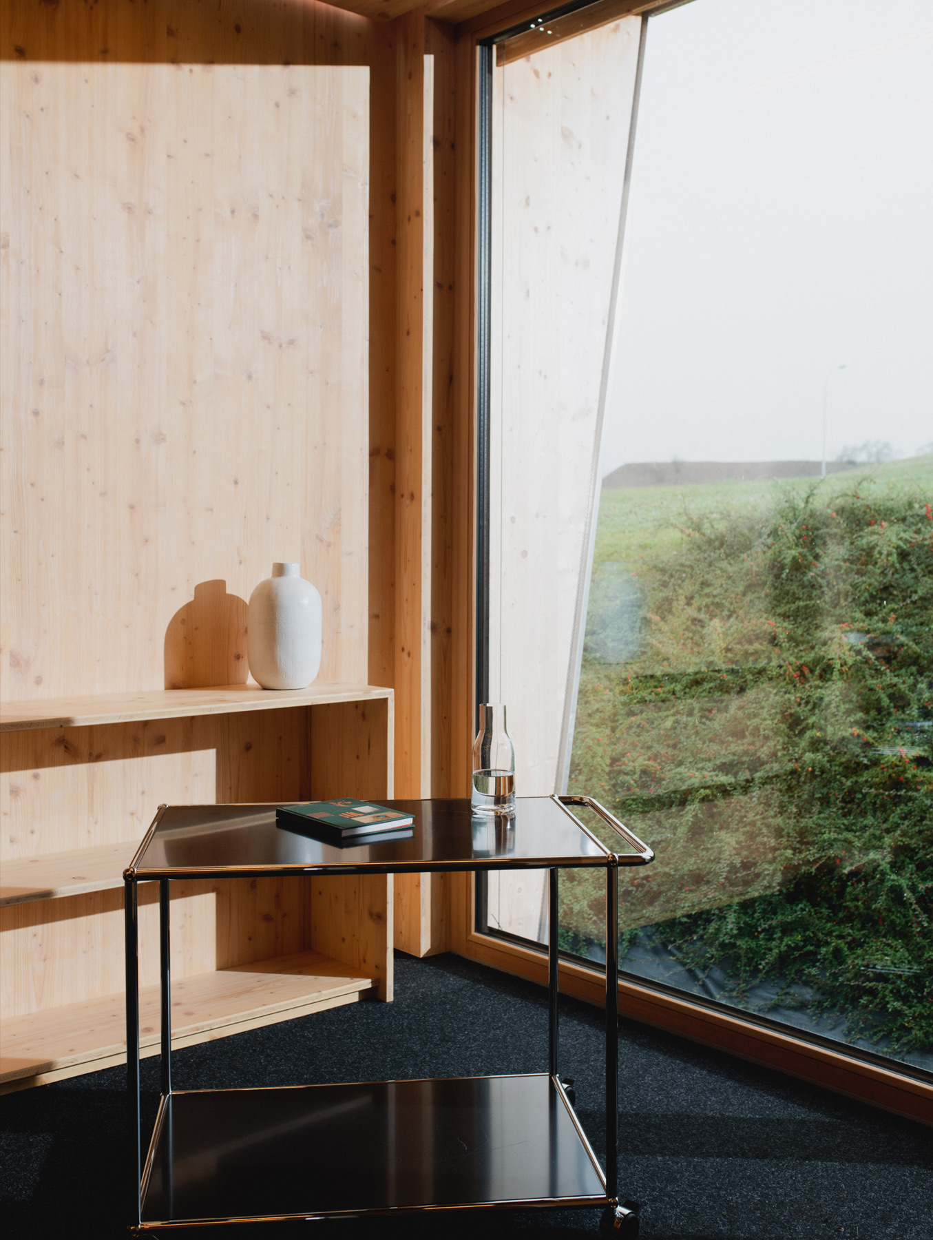 MOHAB Space interior with timber shelf, side table and window view