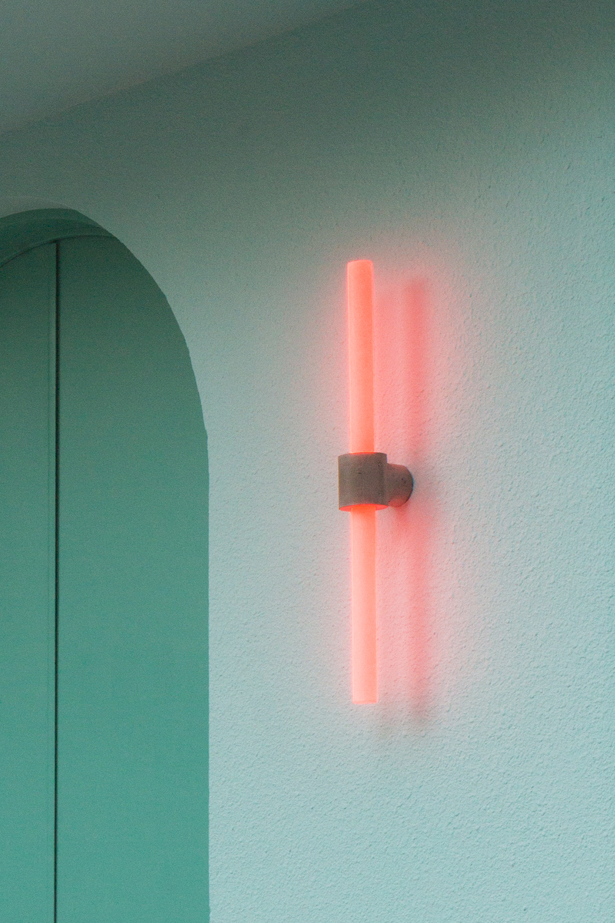 Pink neon wall light against the mint walls and arches inside ORNO