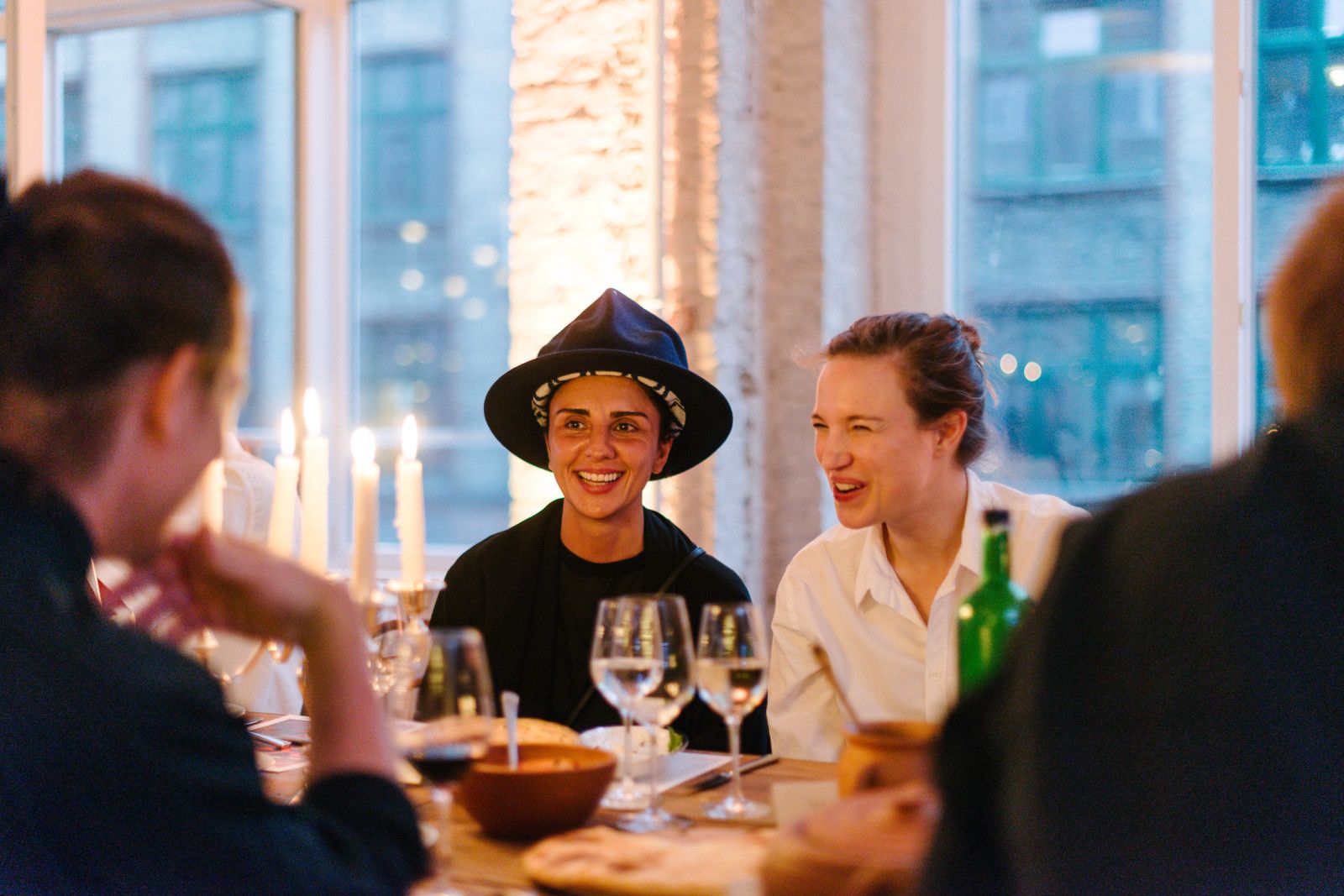 Chef in a hat laughing with guests at the Supra dinner table