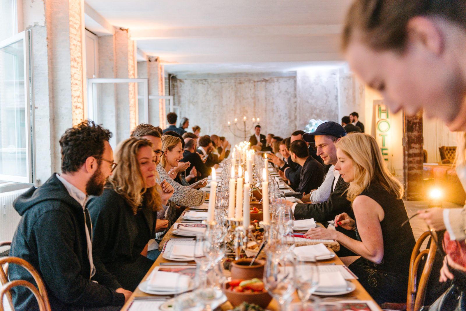 Guests at a long candlelit table during the Georgian Supra dinner for Rooms Hotels