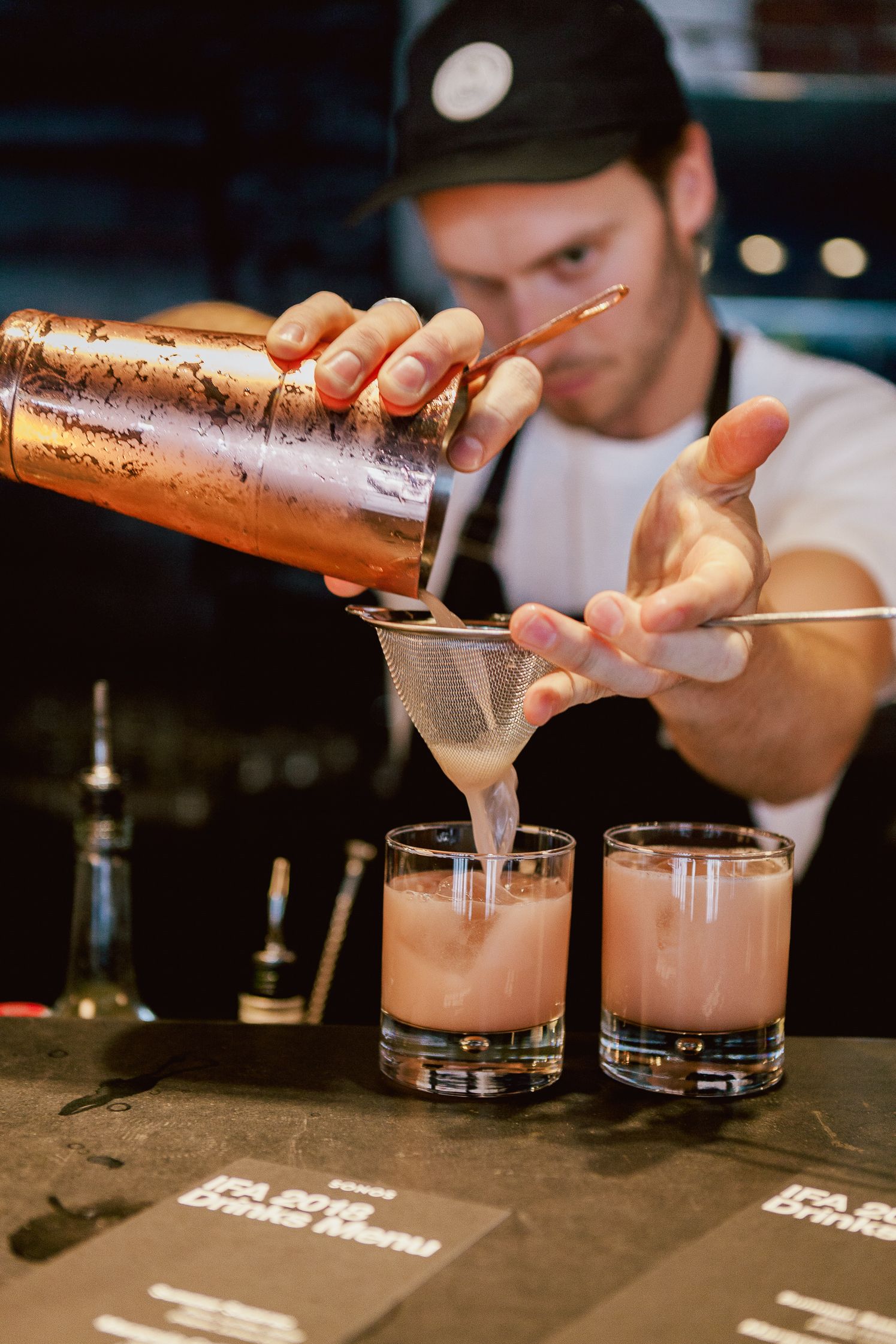 Bartender straining pink cocktails at the Sonos IFA hub bar
