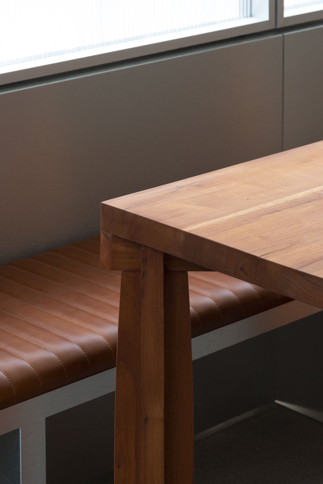 Wooden table and leather bench by the window at Asadero