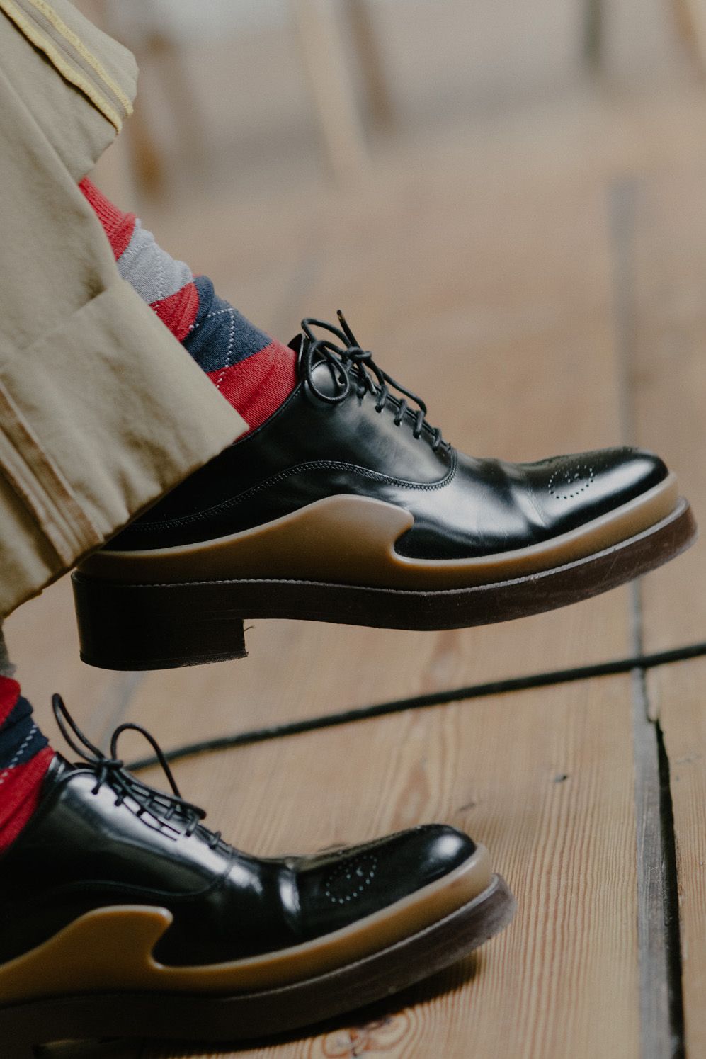 Detail of black leather shoes and patterned socks