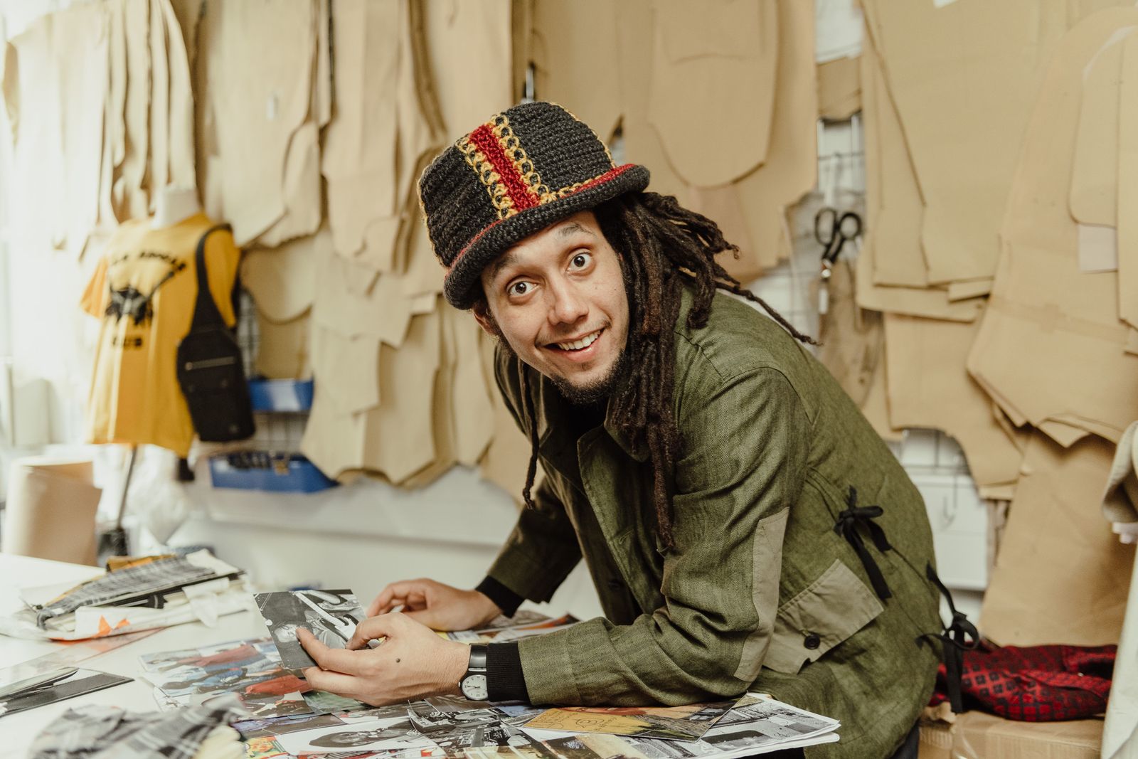 Fashion designer smiling at his work table in a London studio, for The Art of Listening