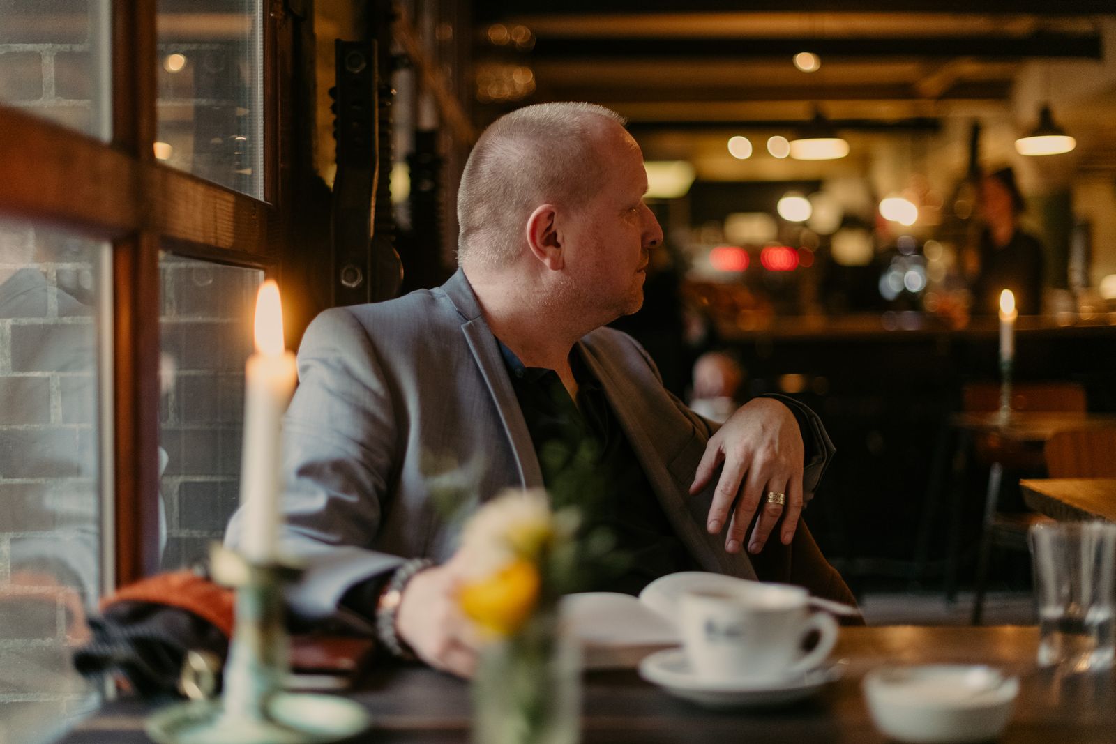 Sound researcher at a candlelit cafe table in Copenhagen