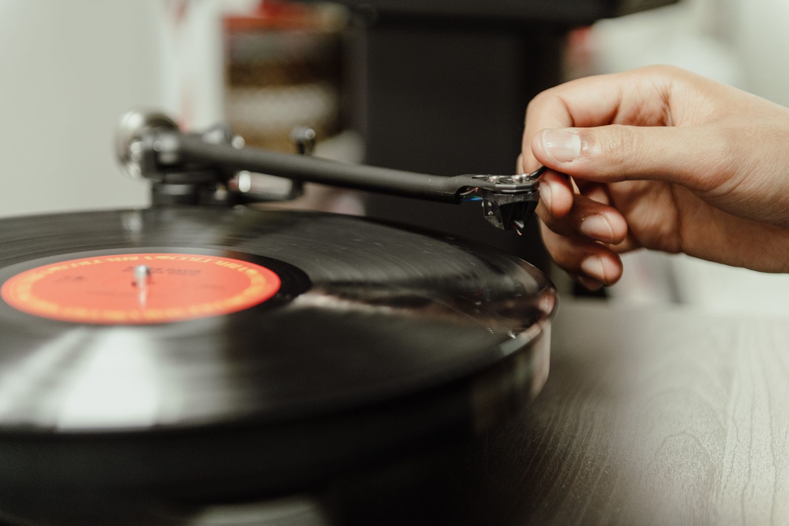 Close-up of a hand placing the needle on a spinning vinyl record