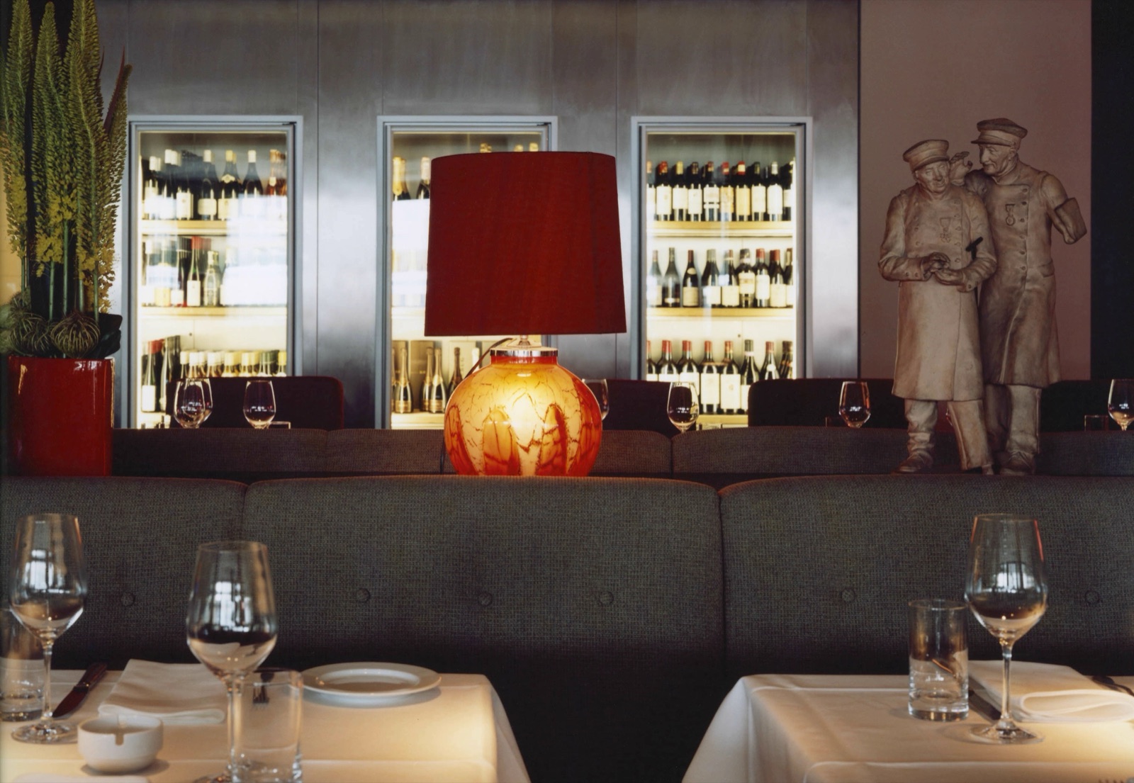 Grill Royal dining room with a red lamp in front of illuminated wine fridges