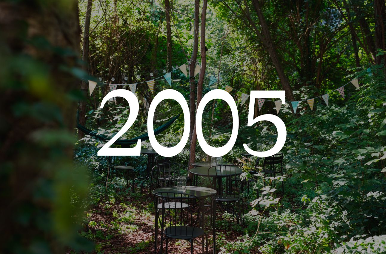Overgrown Berlin garden with bistro tables and bunting, with the year 2005 set over the image