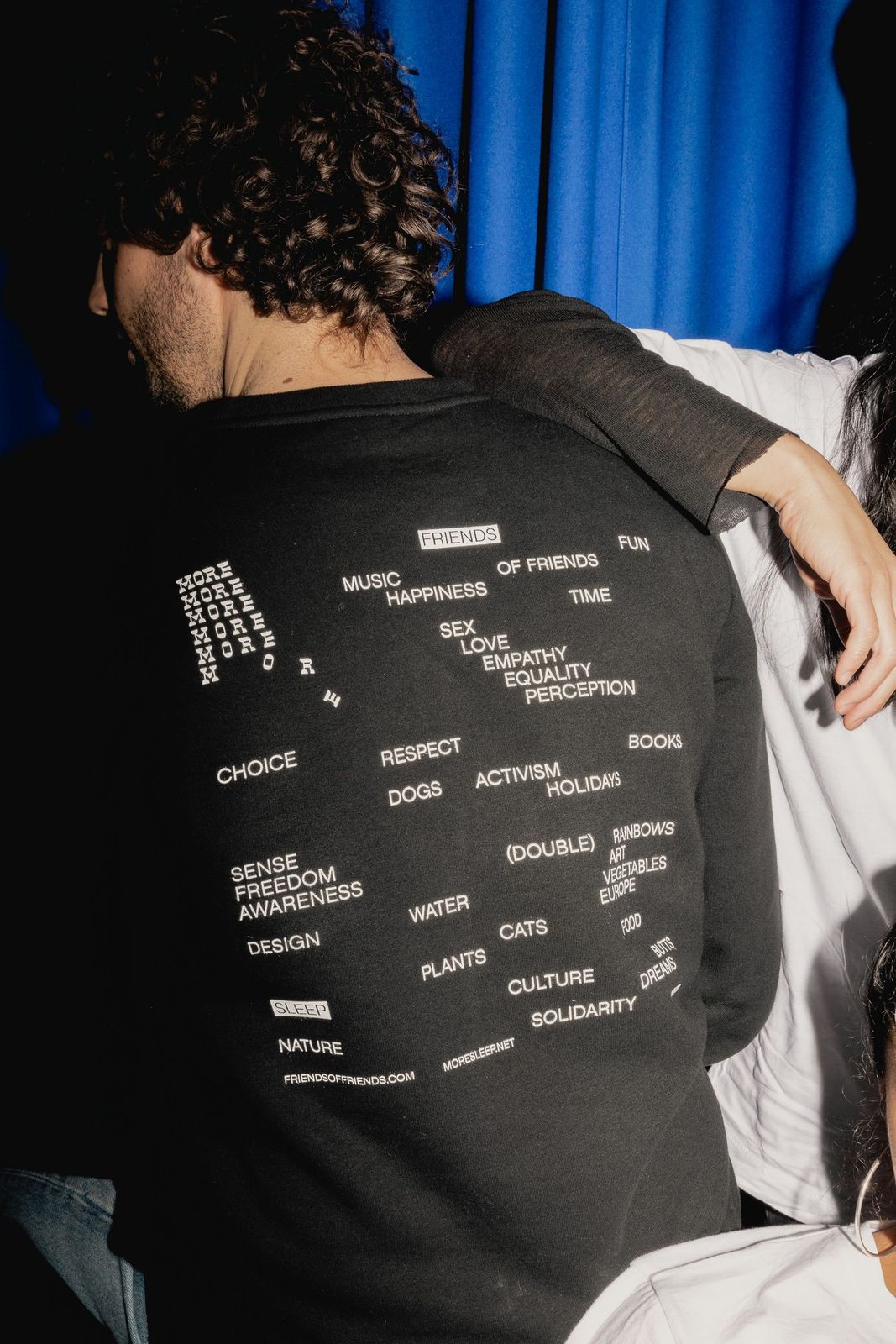 Back of a black T-shirt printed with a list of wishes for the new year