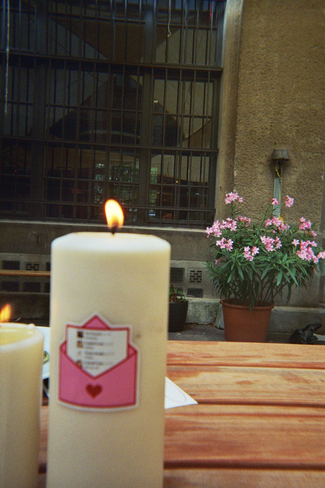 Candle on a garden table next to stickers made from team chat jokes
