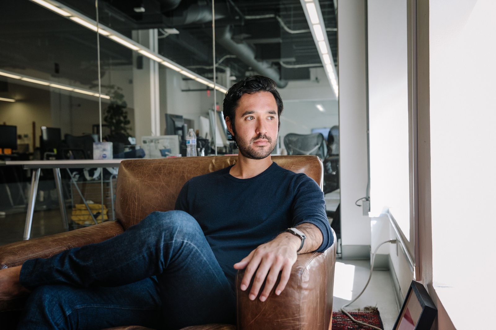 Agency partner in a leather armchair in an open-plan office in San Francisco