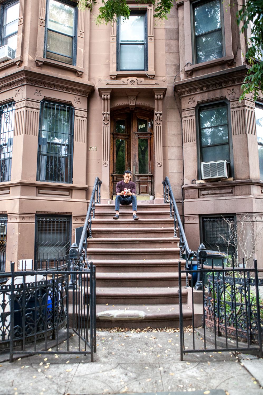 Founder sitting on the stoop of a brownstone in Brooklyn