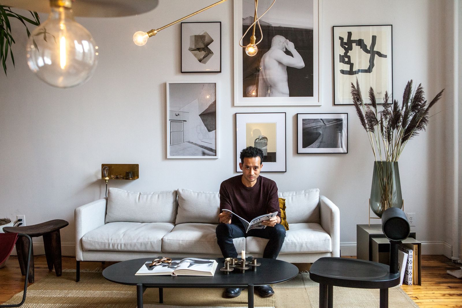 Founder reading on a sofa in a light-filled New York showroom set up like an apartment