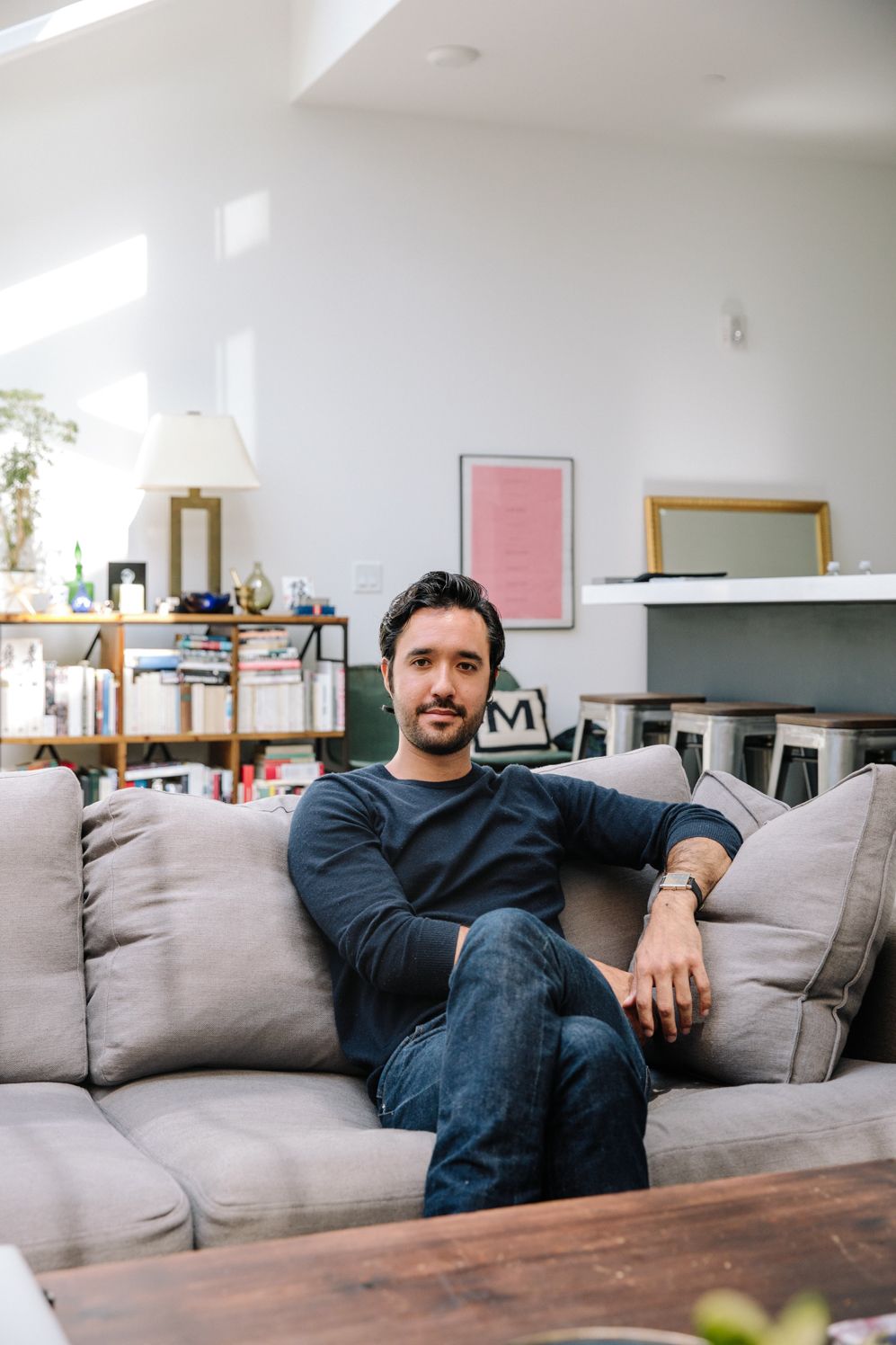 Agency partner relaxing on a grey sofa in his apartment