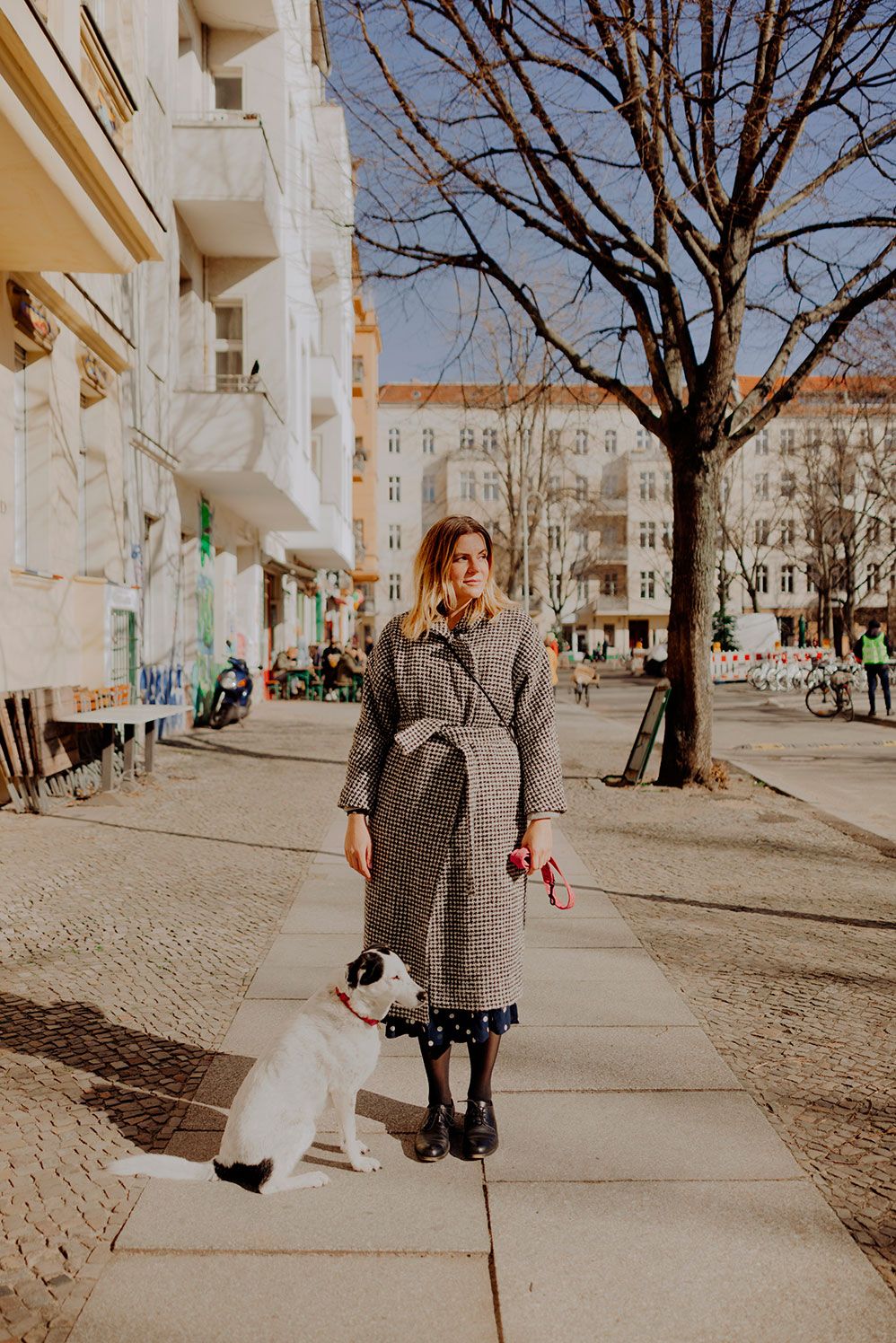Mary Scherpe with her dog on a Berlin sidewalk