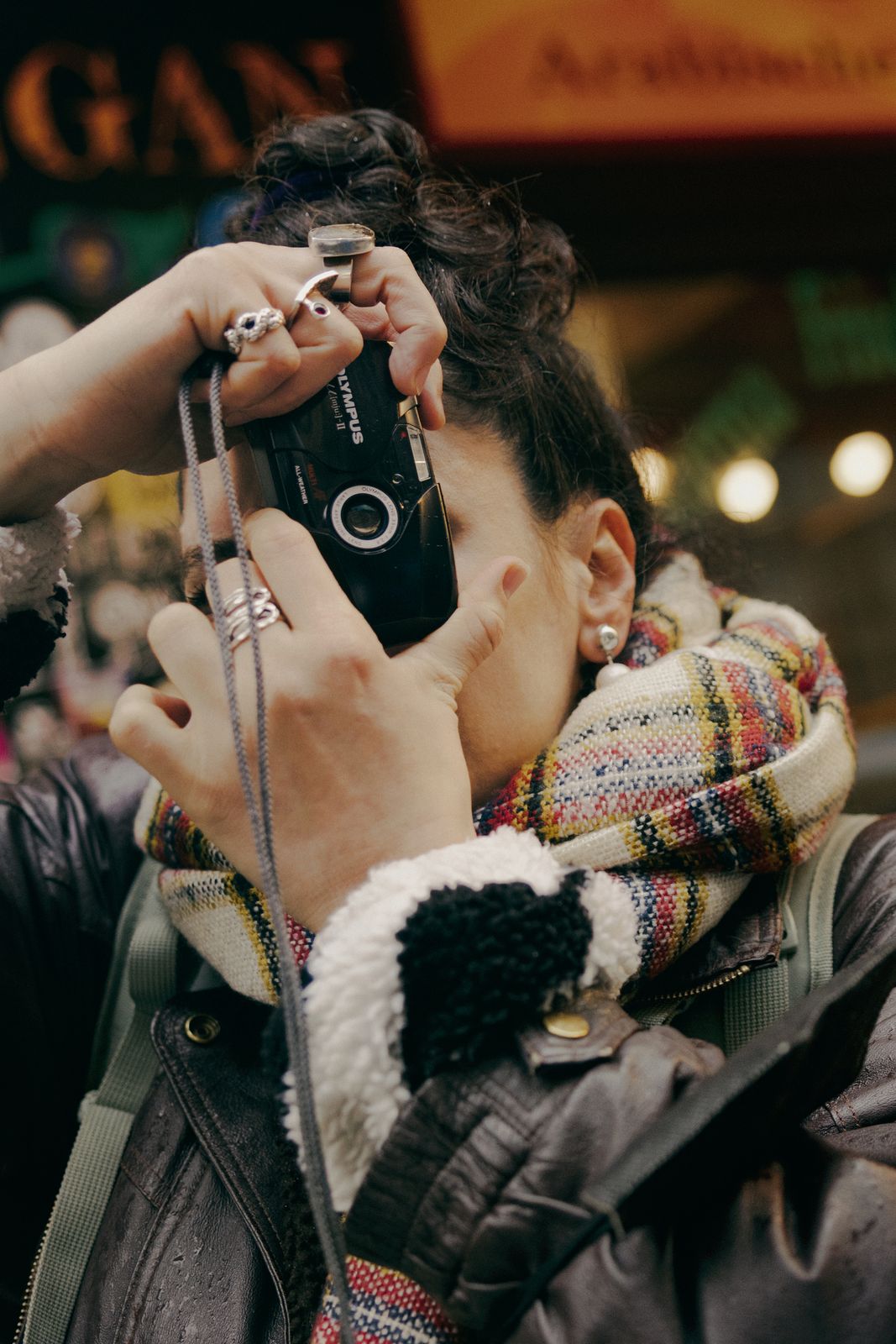 Photographer raising a film camera to her eye