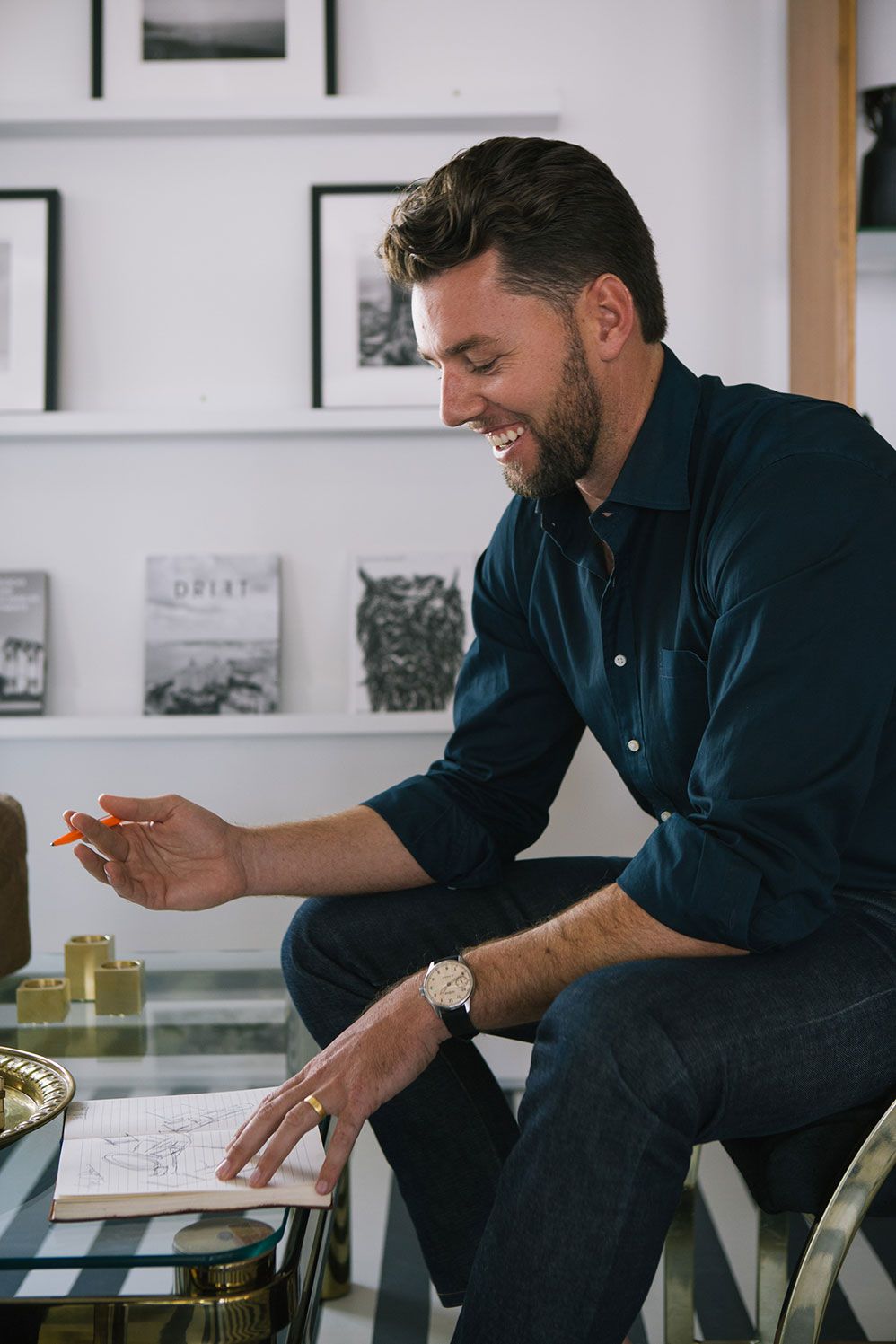 Man in a navy shirt looking through prints at a desk in a white store