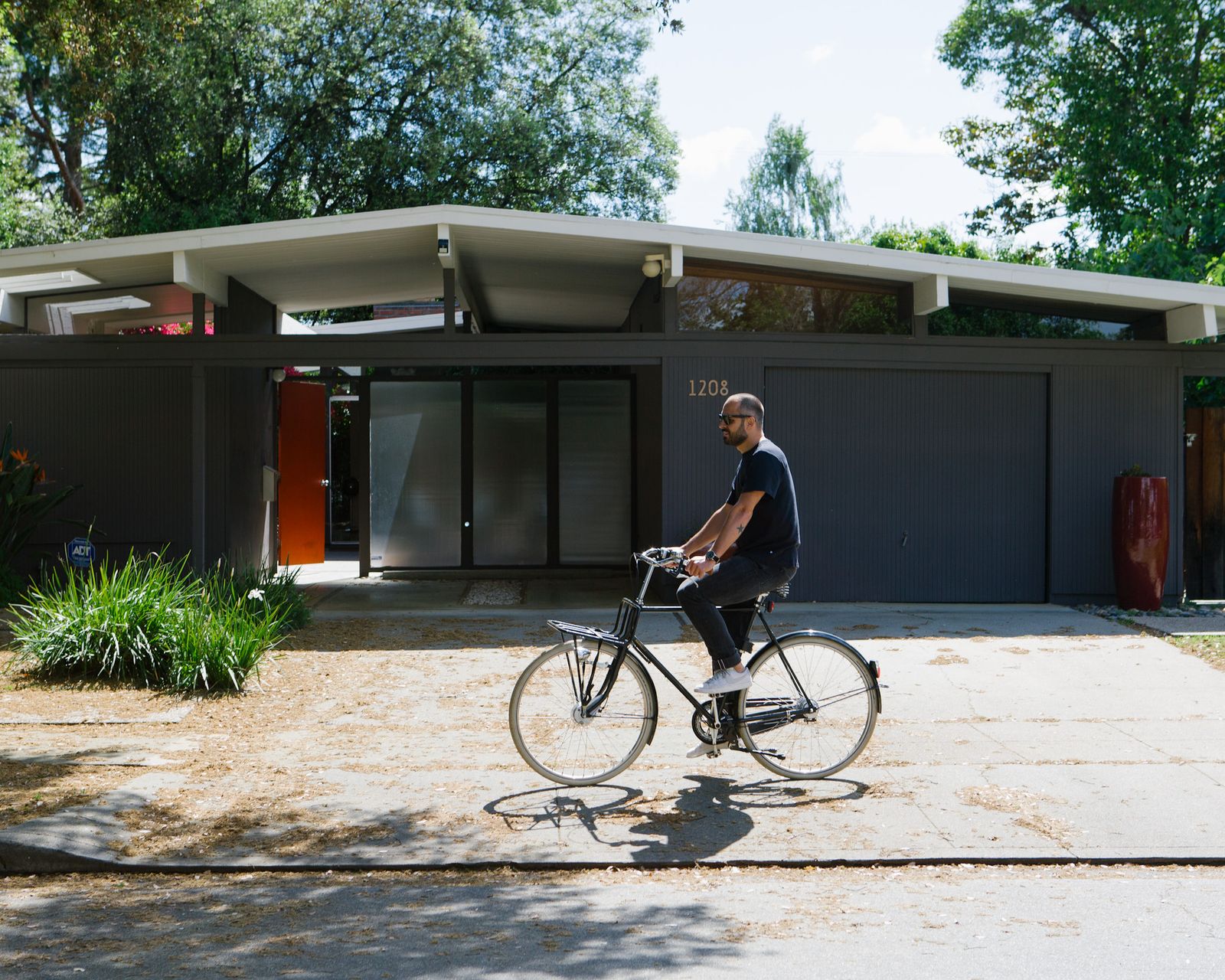 Man cycling past a mid-century Eichler house in Sunnyvale