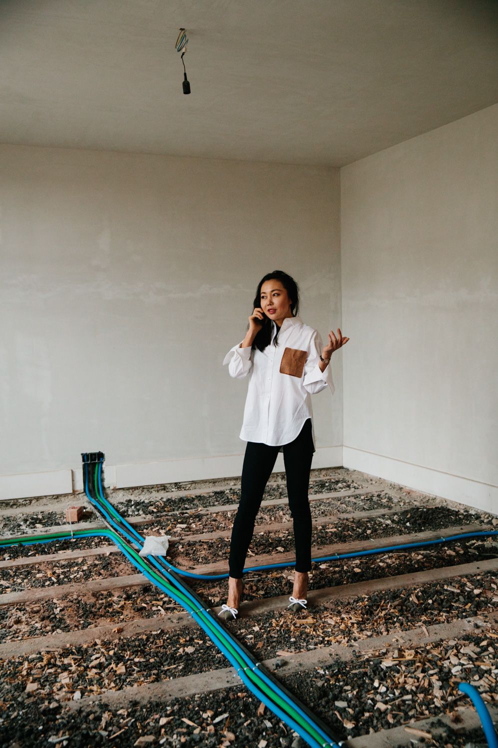 Zhang Xi on the phone in an unfinished room during construction