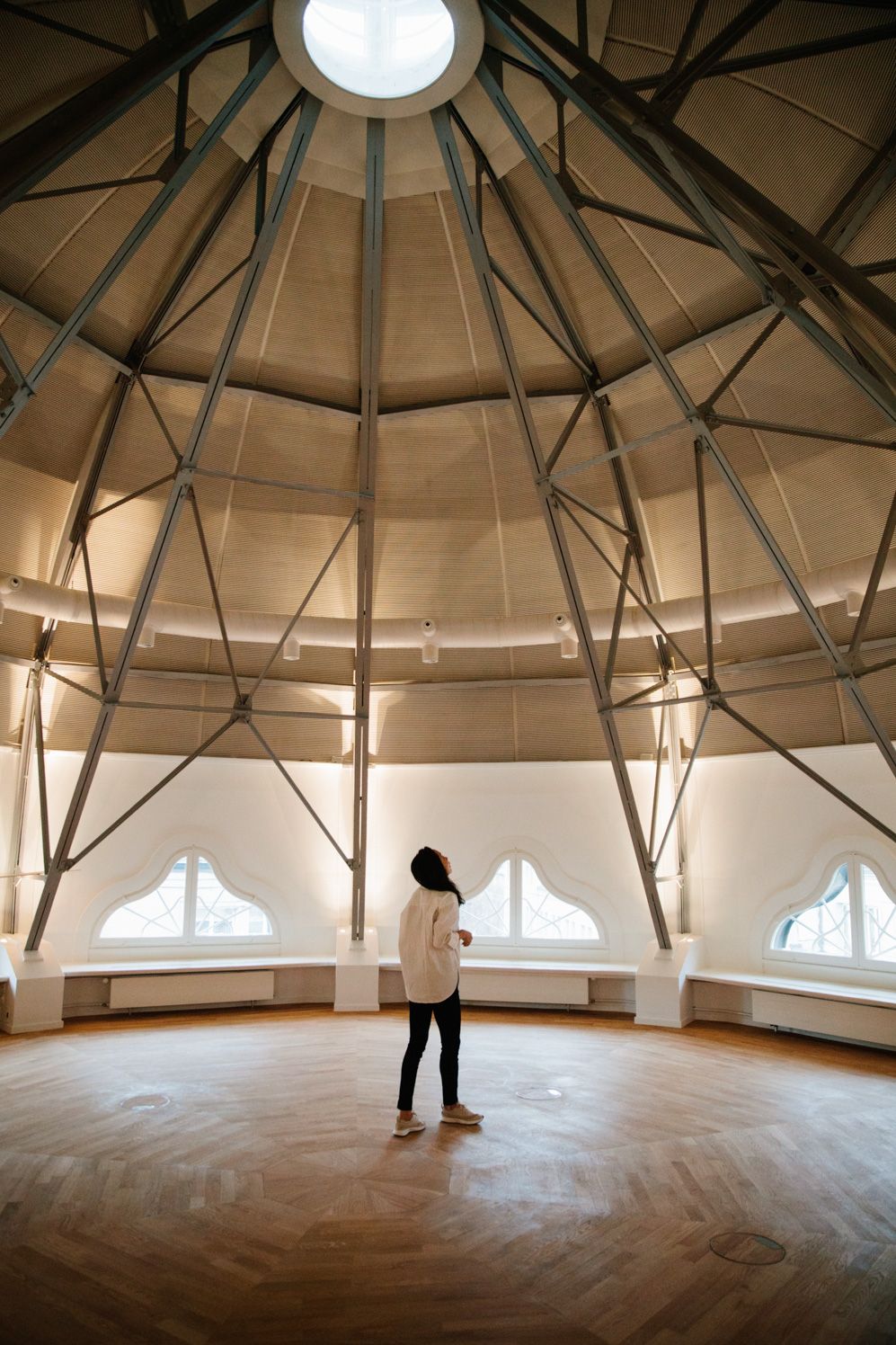 Zhang Xi standing under a domed timber ceiling in a historic Zurich building
